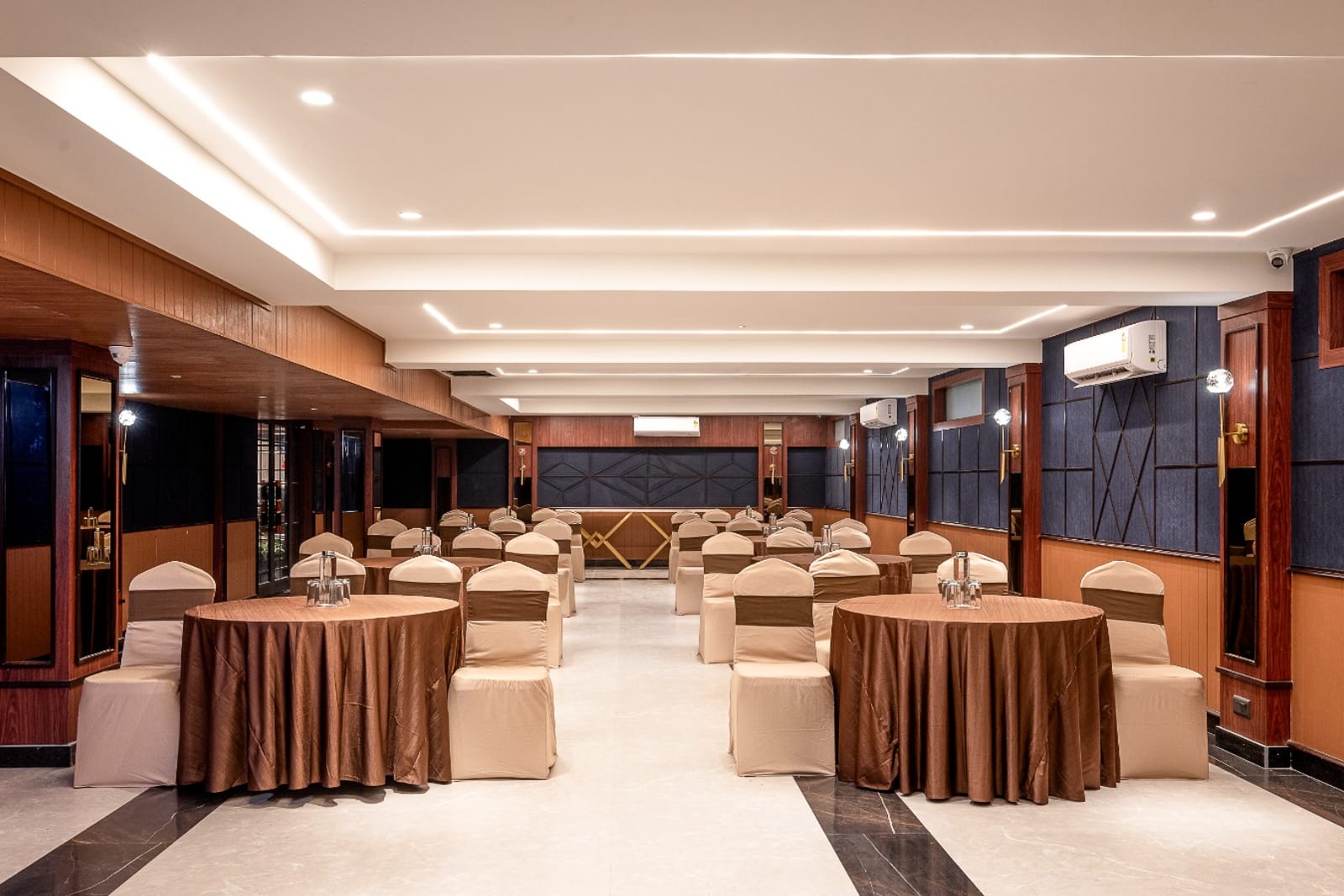 A celebration set up in the banquet hall, with tables dressed for an occasion