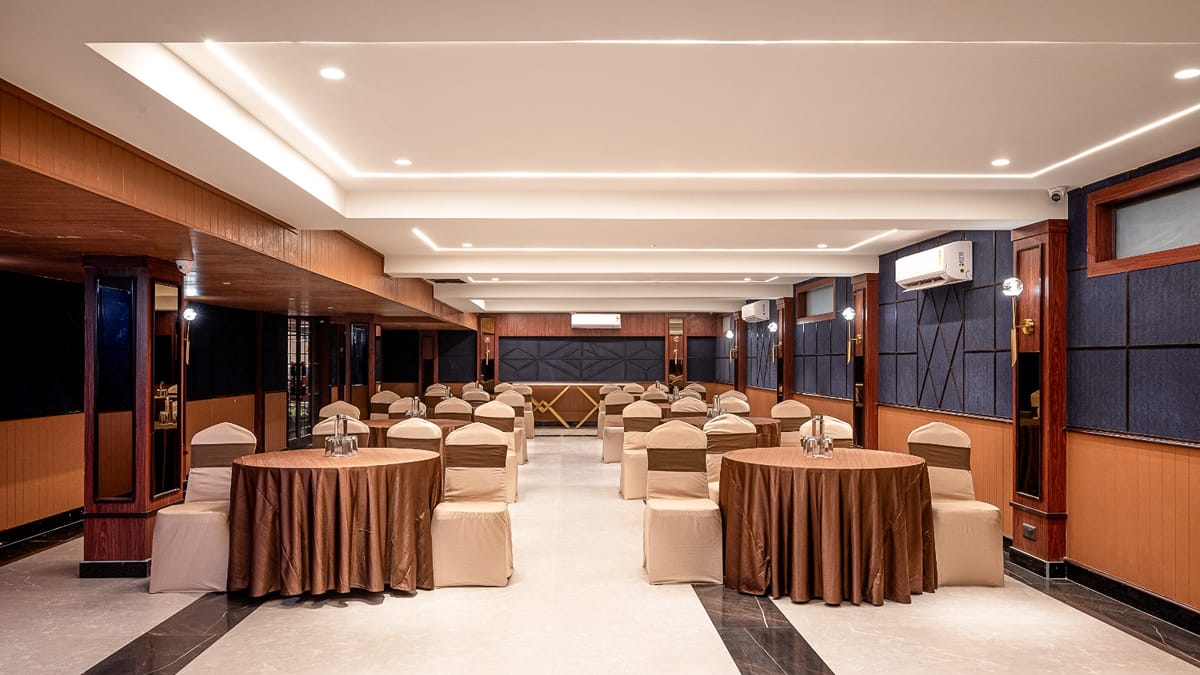 The banquet hall set with round skirted tables beneath a high ceiling