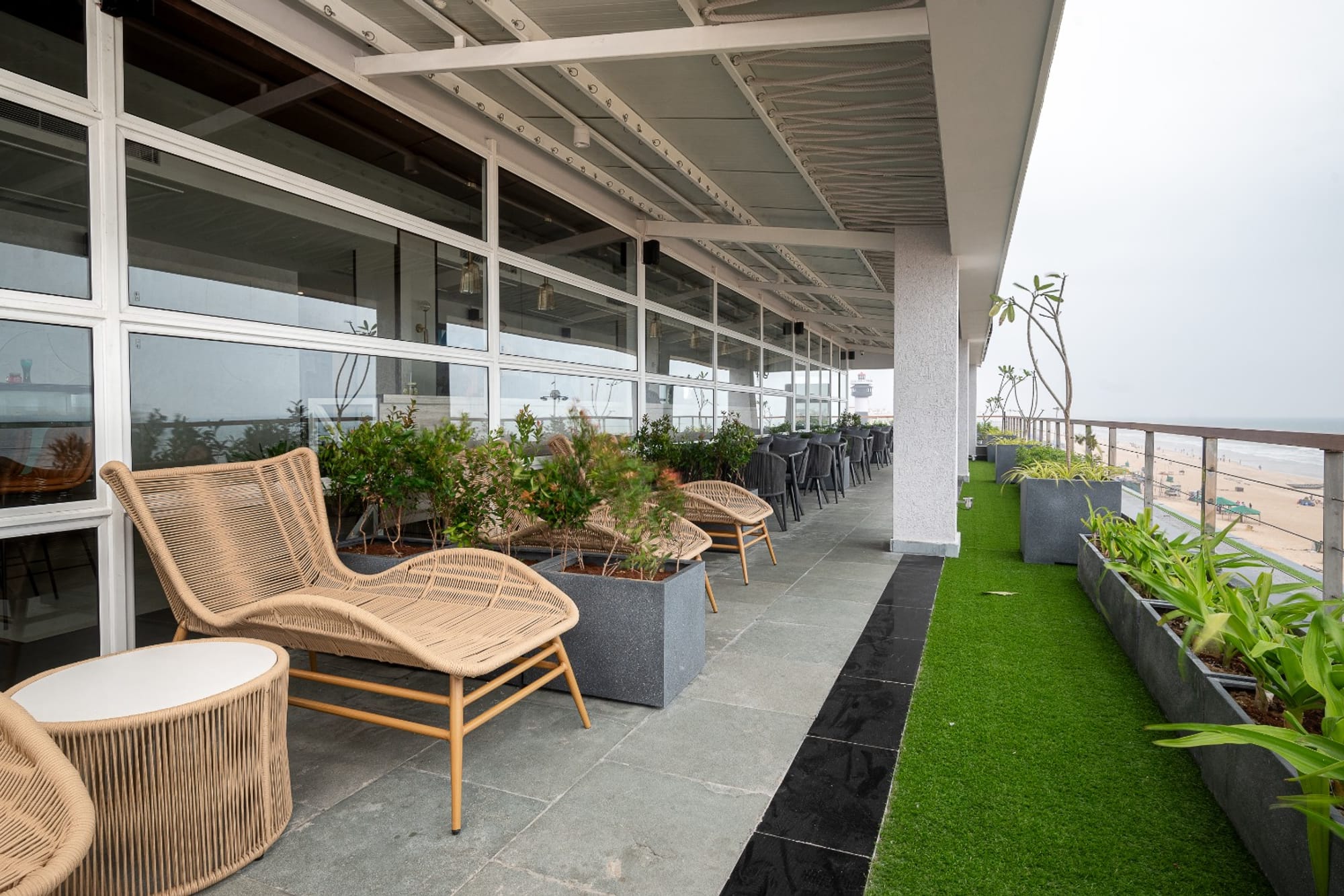 Balcony seating with woven furniture and a glass railing