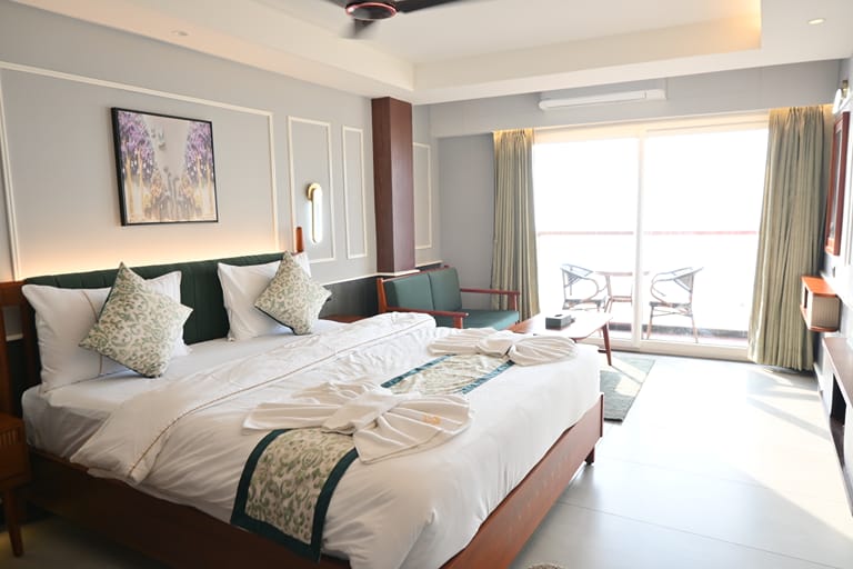 Platinum Double — bright bedroom with dark wood furniture and balcony chairs